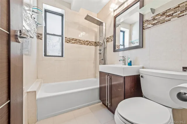 a white toilet sitting next to a bathroom sink and tub