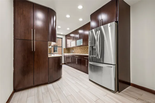 a kitchen with stainless steel appliances granite countertop a refrigerator and a sink