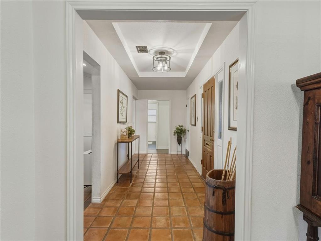 1662 Watson Road Fort Worth, TX 76103 - Photo 5 of 37 Corridor with a tray ceiling and light tile patterned floors