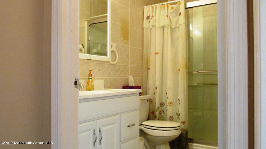 35 A Zacatin Road, Unit 1000 Freehold, NJ 07728 - Photo 11 of 16 a bathroom with a sink a toilet and shower