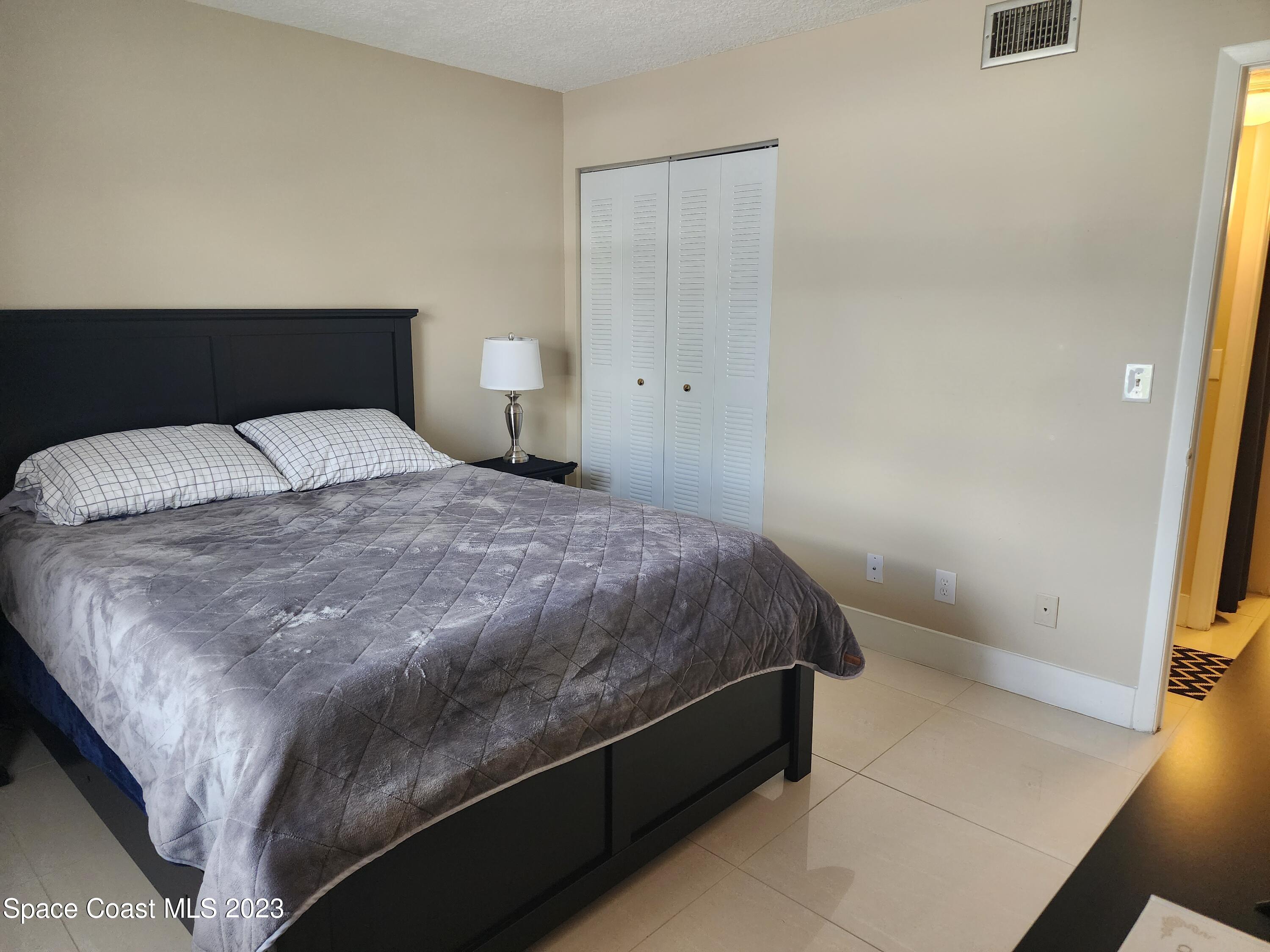 582 North Wickham Road, Unit 89 Melbourne, FL 32934 - Photo 15 of 25 a bedroom with a bed and a shower