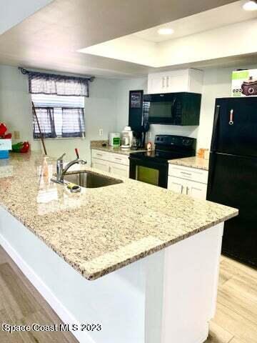 582 North Wickham Road, Unit 89 Melbourne, FL 32934 - Photo 24 of 25 a kitchen with kitchen island a sink stainless steel appliances and counter space