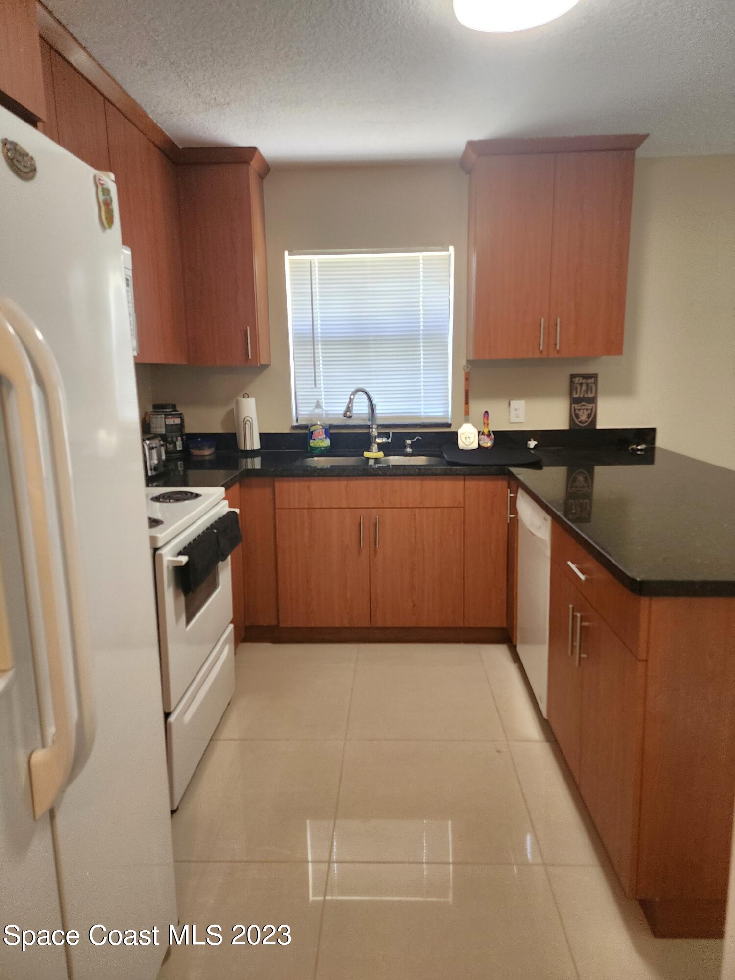 582 North Wickham Road, Unit 89 Melbourne, FL 32934 - Photo 3 of 25 a kitchen with stainless steel appliances granite countertop a stove a sink dishwasher and a refrigerator