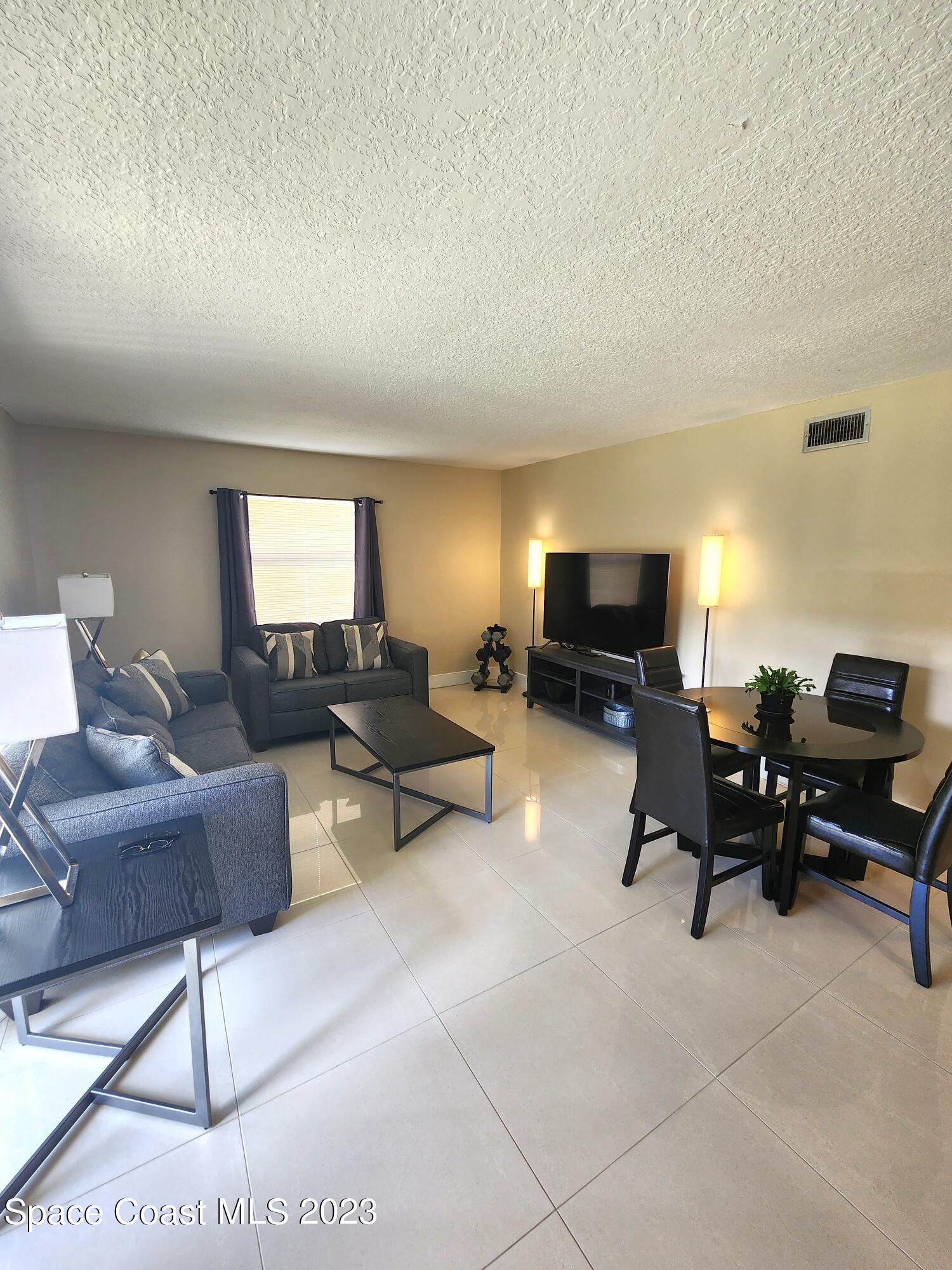 582 North Wickham Road, Unit 89 Melbourne, FL 32934 - Photo 8 of 25 a living room with furniture and a flat screen tv