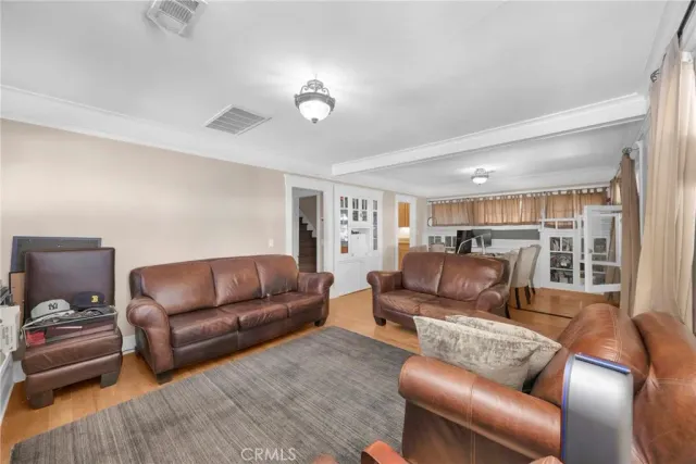 a kitchen with stainless steel appliances granite countertop wooden cabinets a sink a stove a dining table and chairs