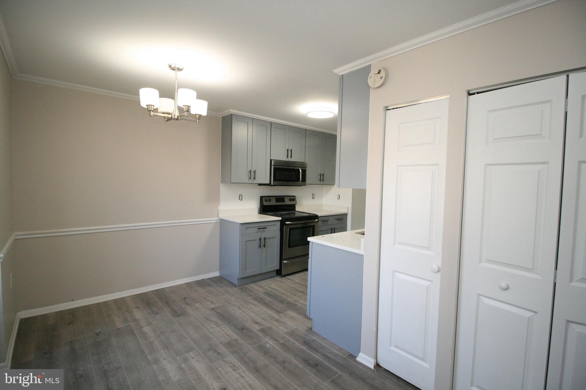 8943 Centerway Road Gaithersburg, MD 20879 - Photo 11 of 34 a view of a kitchen with a sink and dishwasher a refrigerator with wooden floor