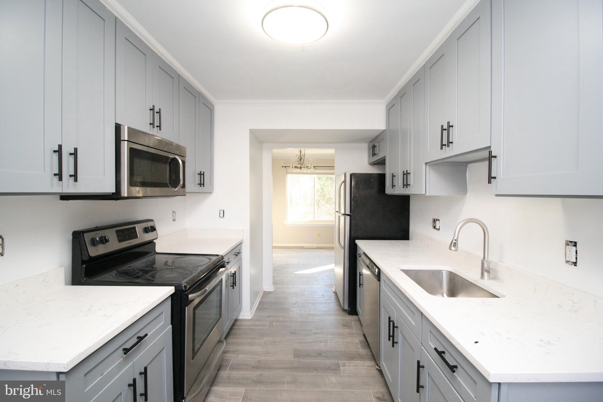 8943 Centerway Road Gaithersburg, MD 20879 - Photo 12 of 34 a kitchen with a sink a stove and refrigerator