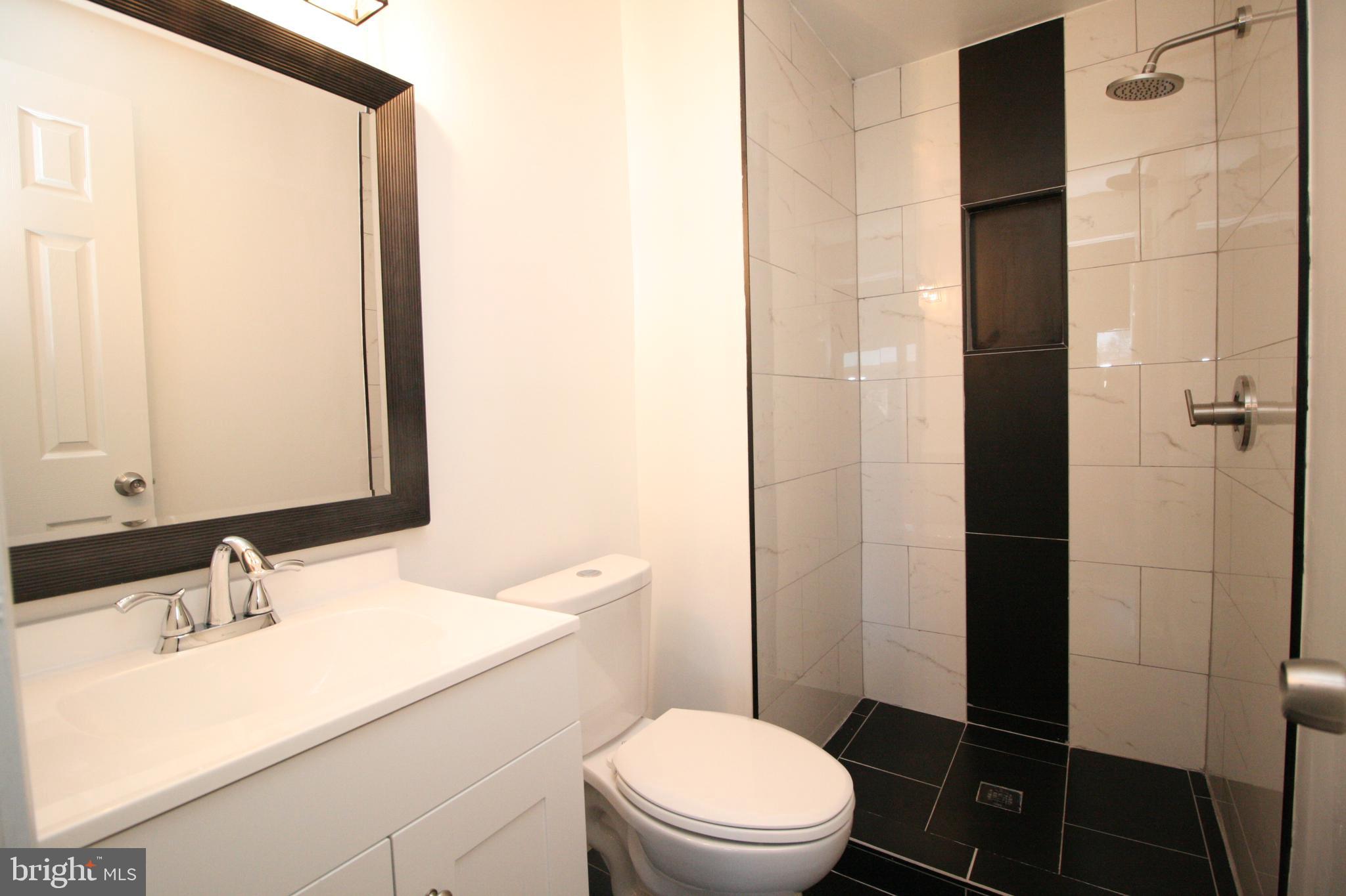 8943 Centerway Road Gaithersburg, MD 20879 - Photo 19 of 34 a bathroom with a sink a toilet and shower