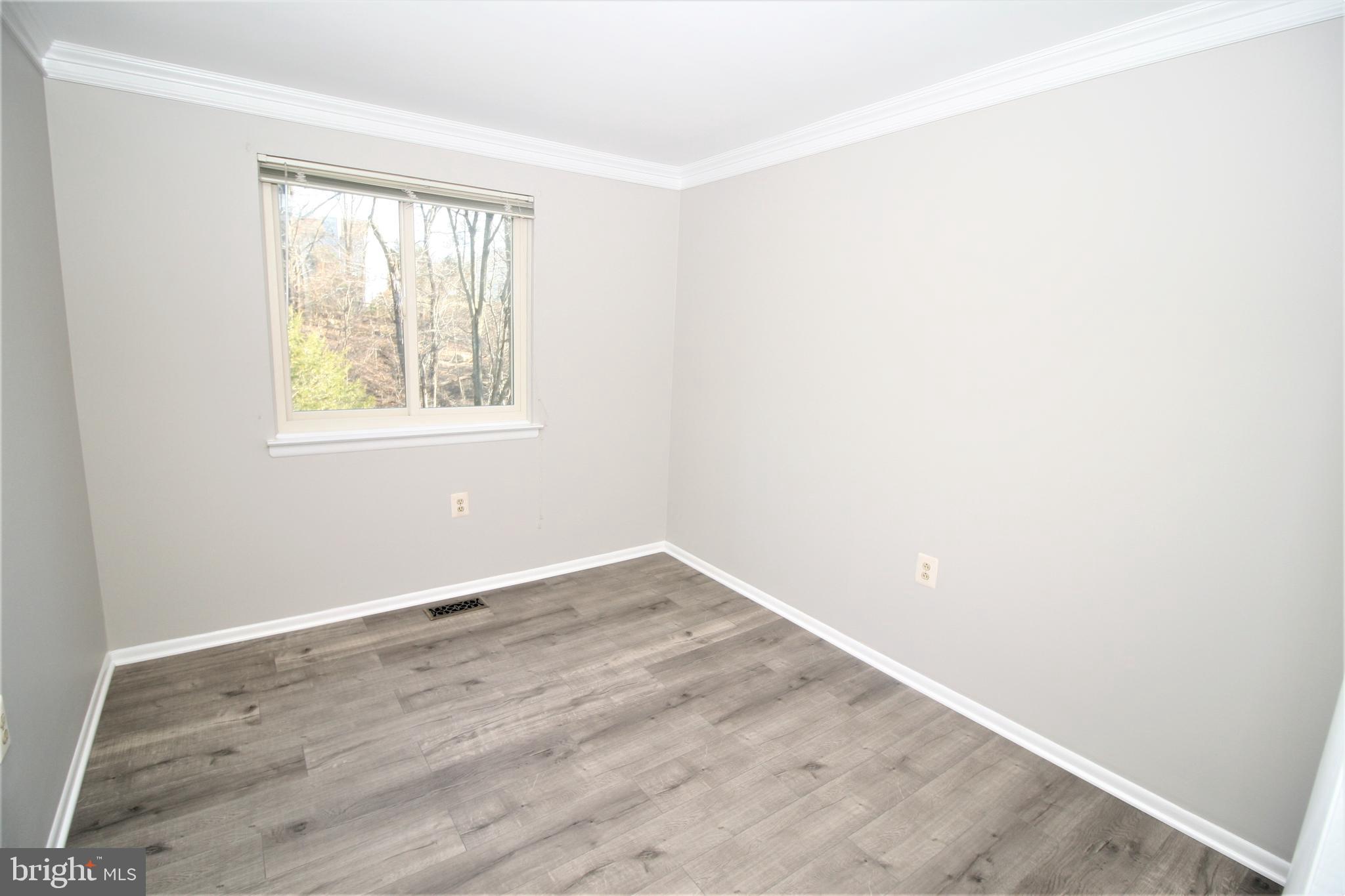 8943 Centerway Road Gaithersburg, MD 20879 - Photo 21 of 34 an empty room with wooden floor and windows