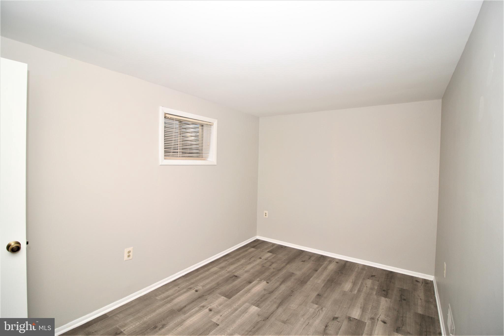 8943 Centerway Road Gaithersburg, MD 20879 - Photo 31 of 34 an empty room with wooden floor and windows
