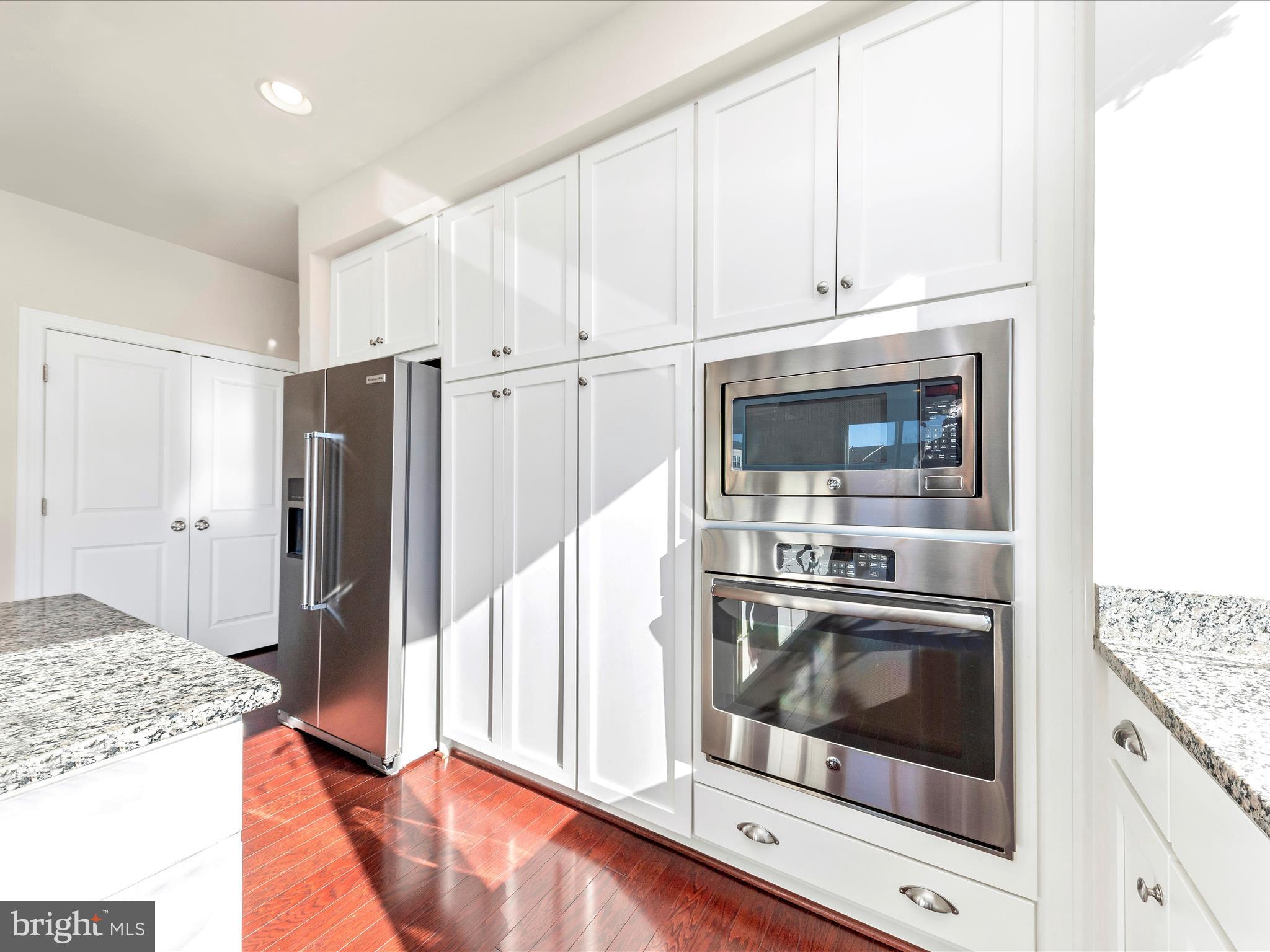42251 Riggins Ridge Terrace Brambleton, VA 20148 - Photo 16 of 62 a kitchen with stainless steel appliances granite countertop a stove microwave and refrigerator