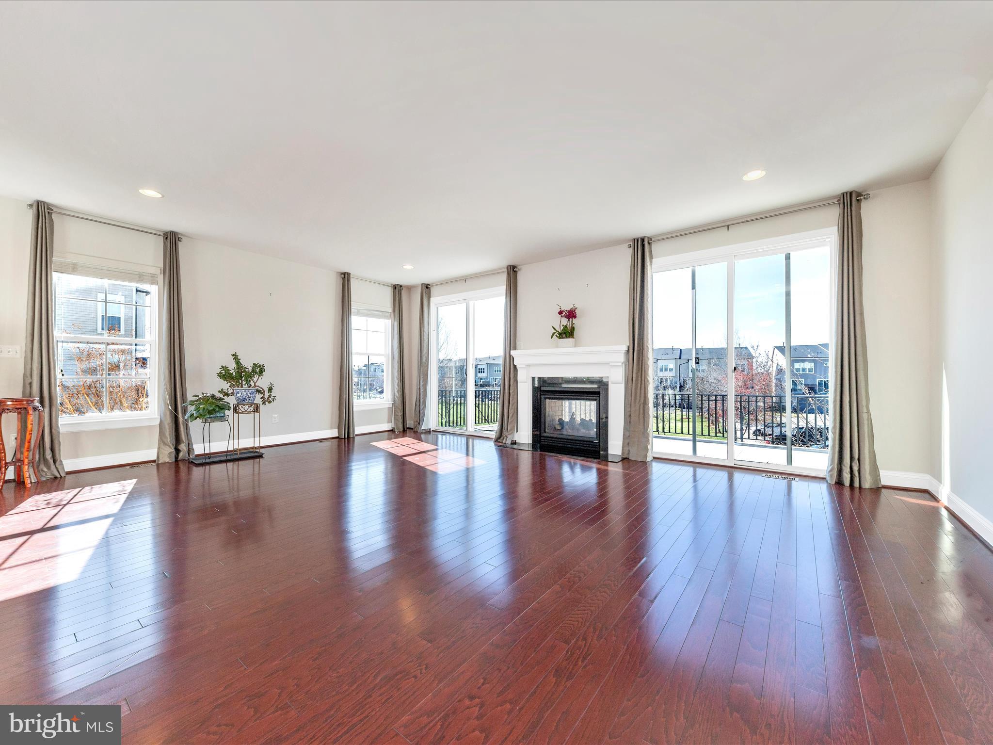 42251 Riggins Ridge Terrace Brambleton, VA 20148 - Photo 20 of 62 a view of an empty room with wooden floor and a floor to ceiling window