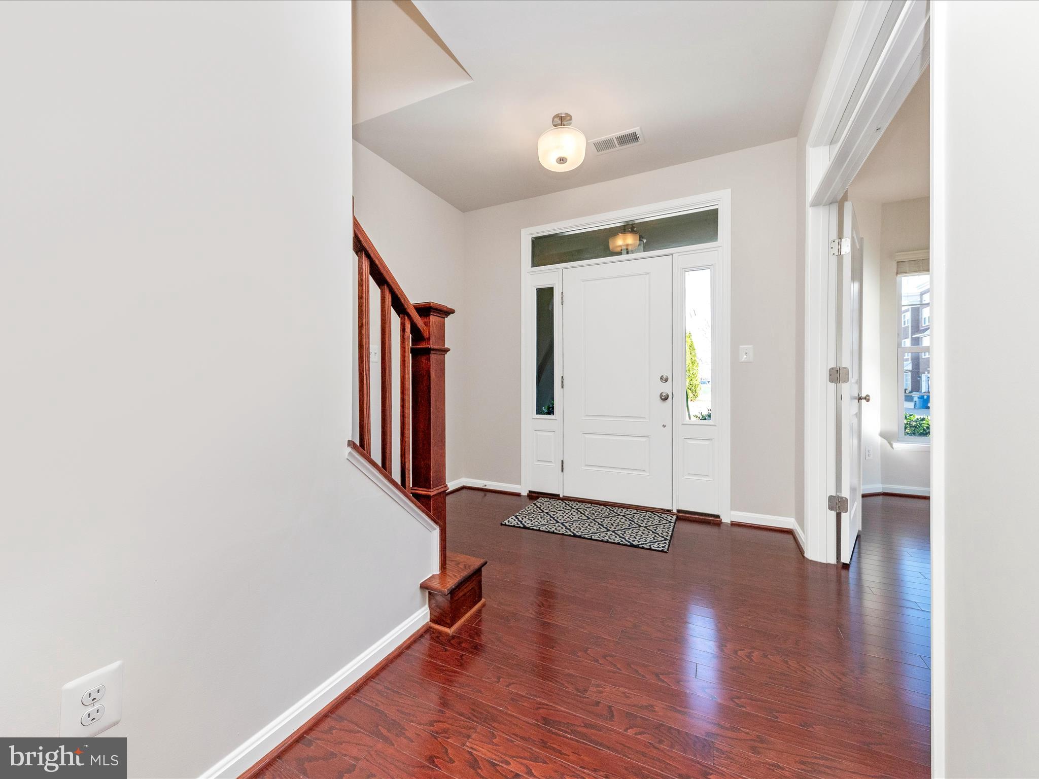 42251 Riggins Ridge Terrace Brambleton, VA 20148 - Photo 2 of 62 a view of an empty room with wooden floor and a window
