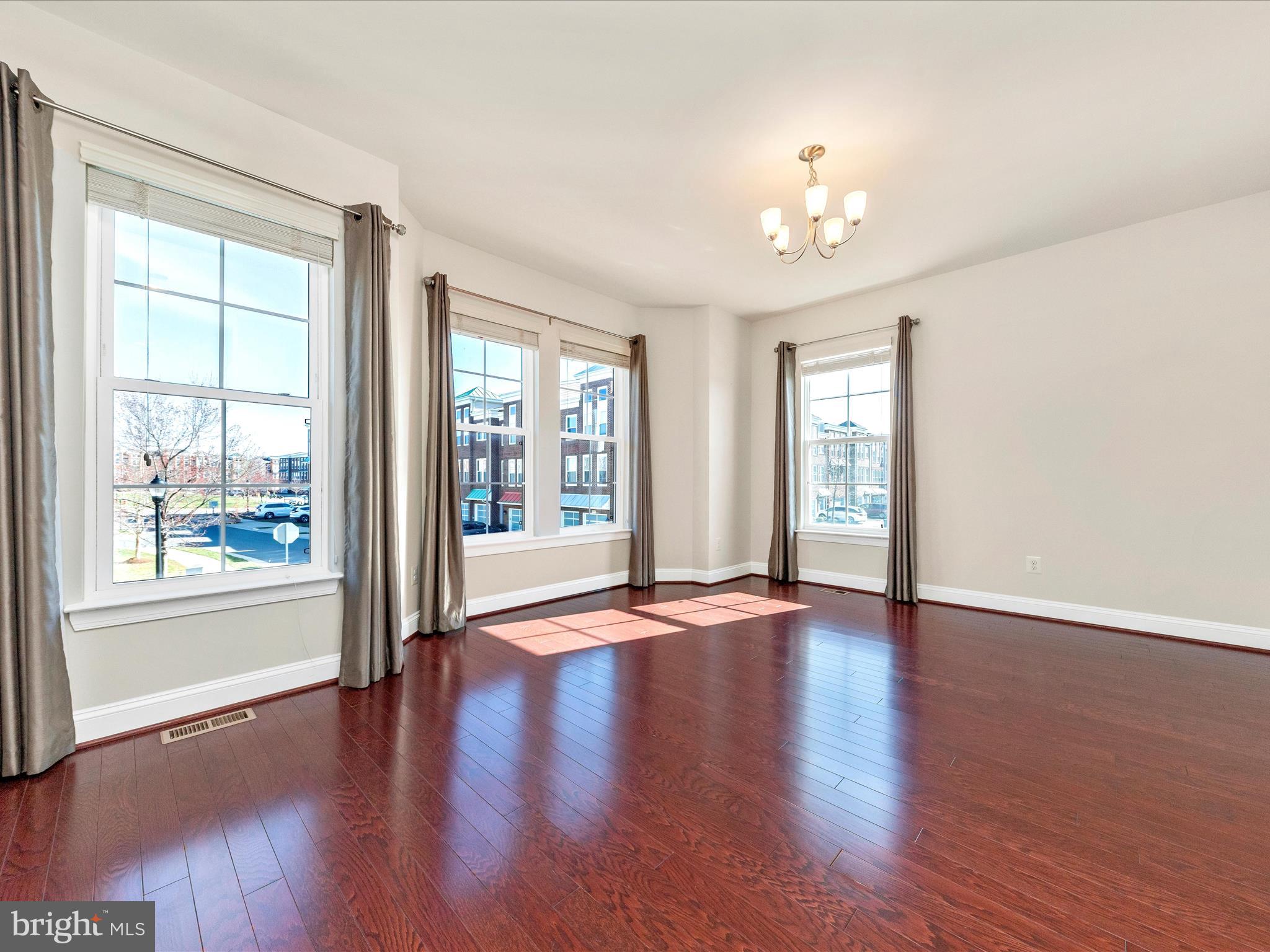 42251 Riggins Ridge Terrace Brambleton, VA 20148 - Photo 26 of 62 a view of an empty room with wooden floor and a window