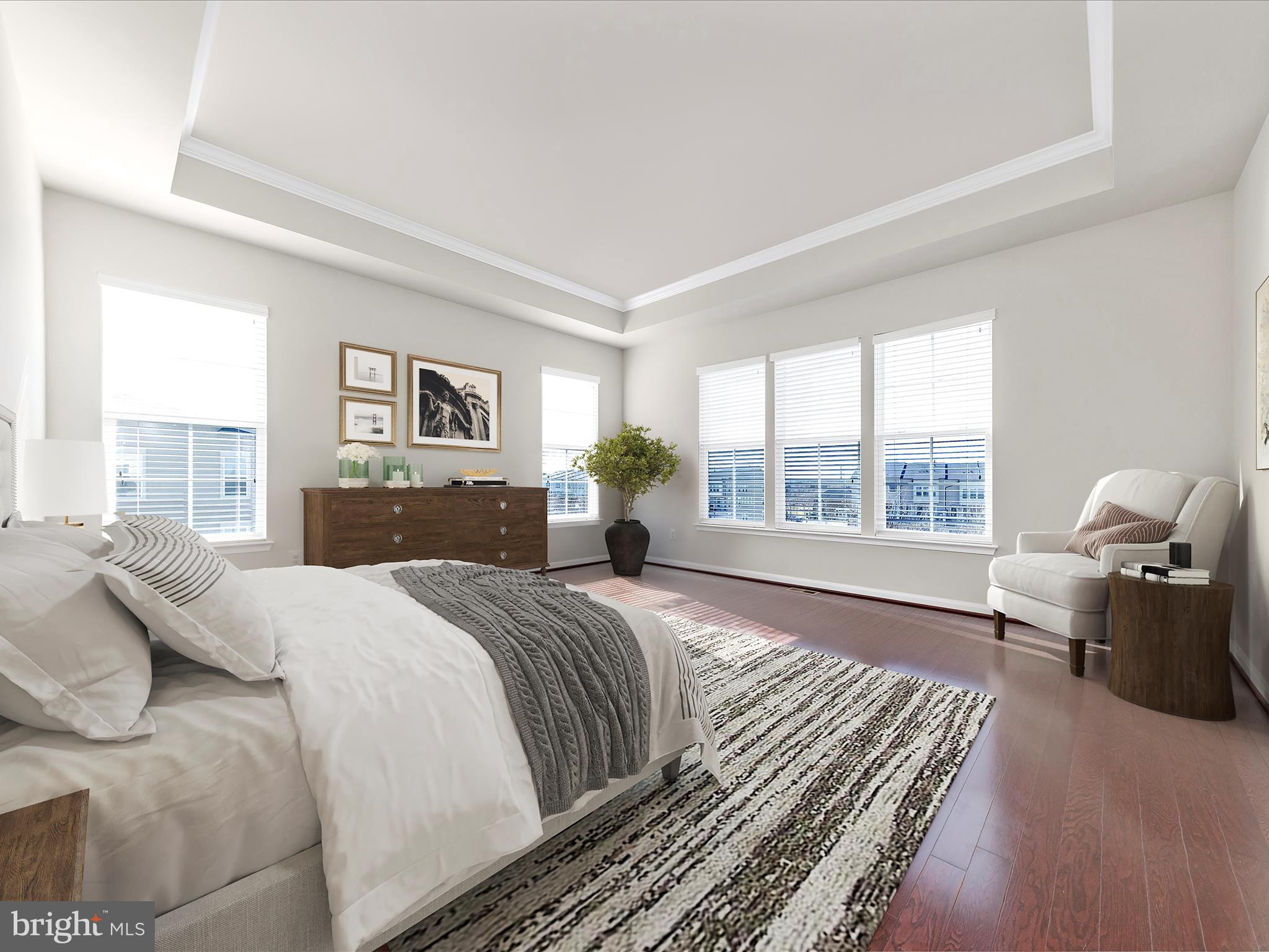 42251 Riggins Ridge Terrace Brambleton, VA 20148 - Photo 31 of 62 a spacious bedroom with a bed and wooden floor