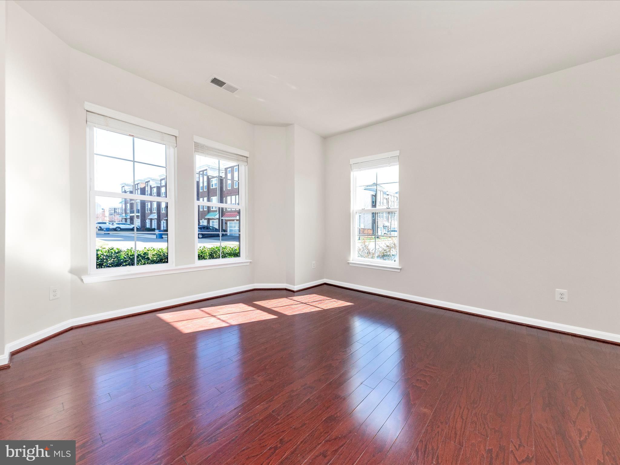 42251 Riggins Ridge Terrace Brambleton, VA 20148 - Photo 4 of 62 a view of an empty room with wooden floor and a window