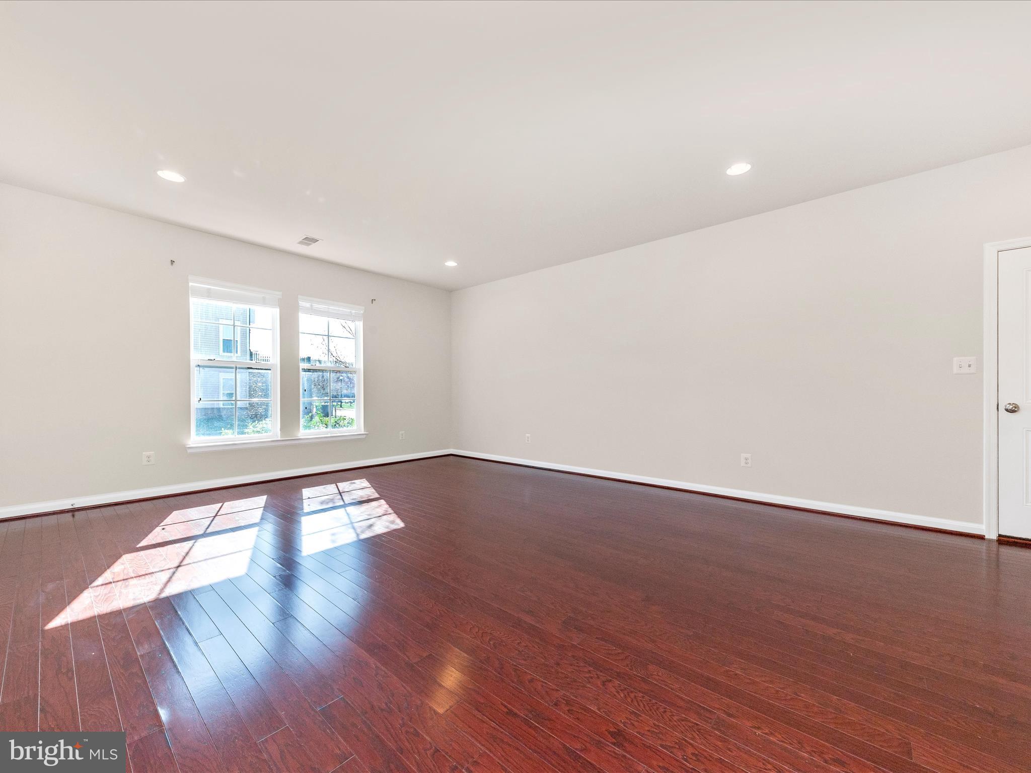 42251 Riggins Ridge Terrace Brambleton, VA 20148 - Photo 7 of 62 a view of an empty room with wooden floor and a window