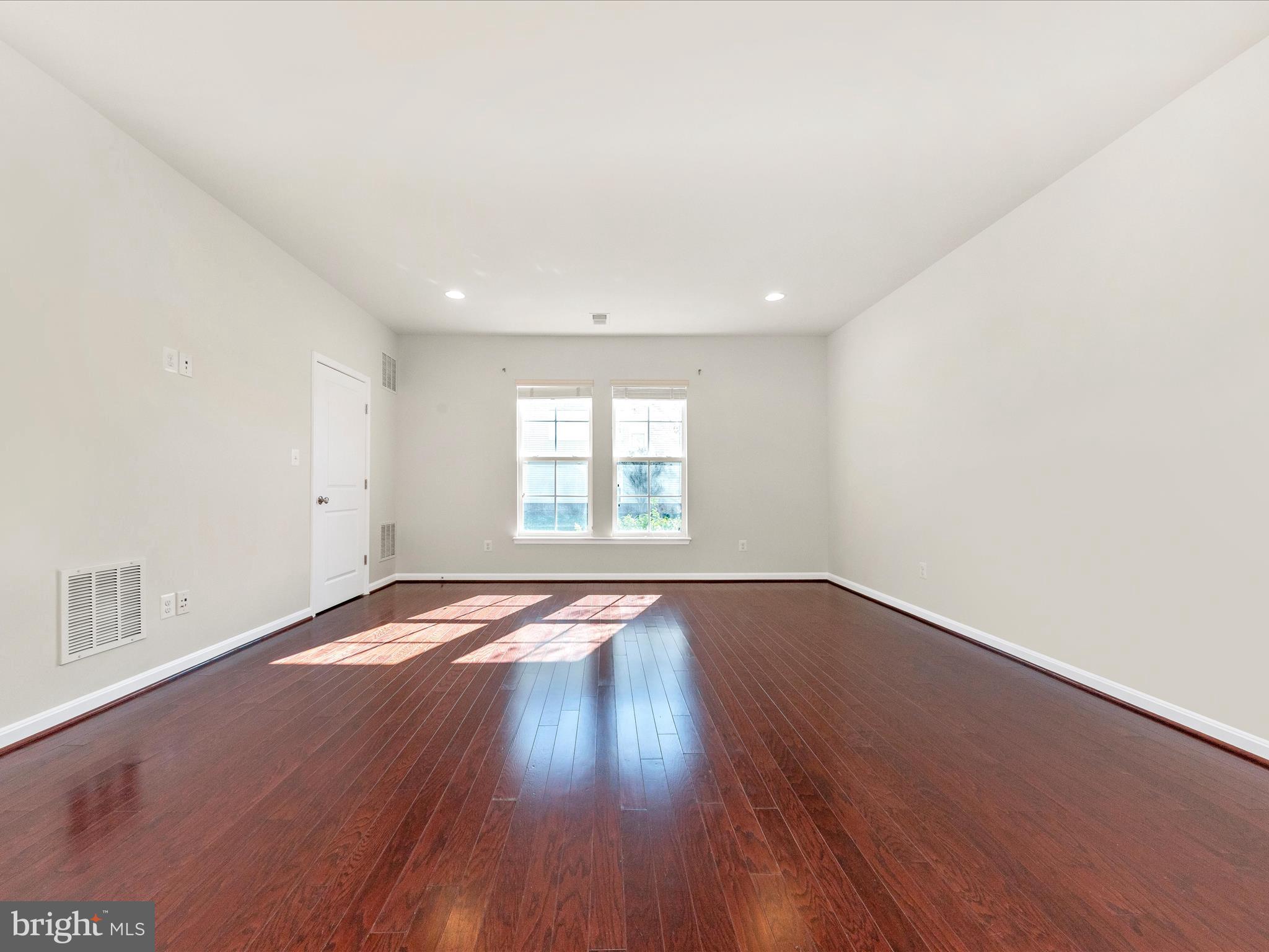 42251 Riggins Ridge Terrace Brambleton, VA 20148 - Photo 8 of 62 an empty room with wooden floor and windows