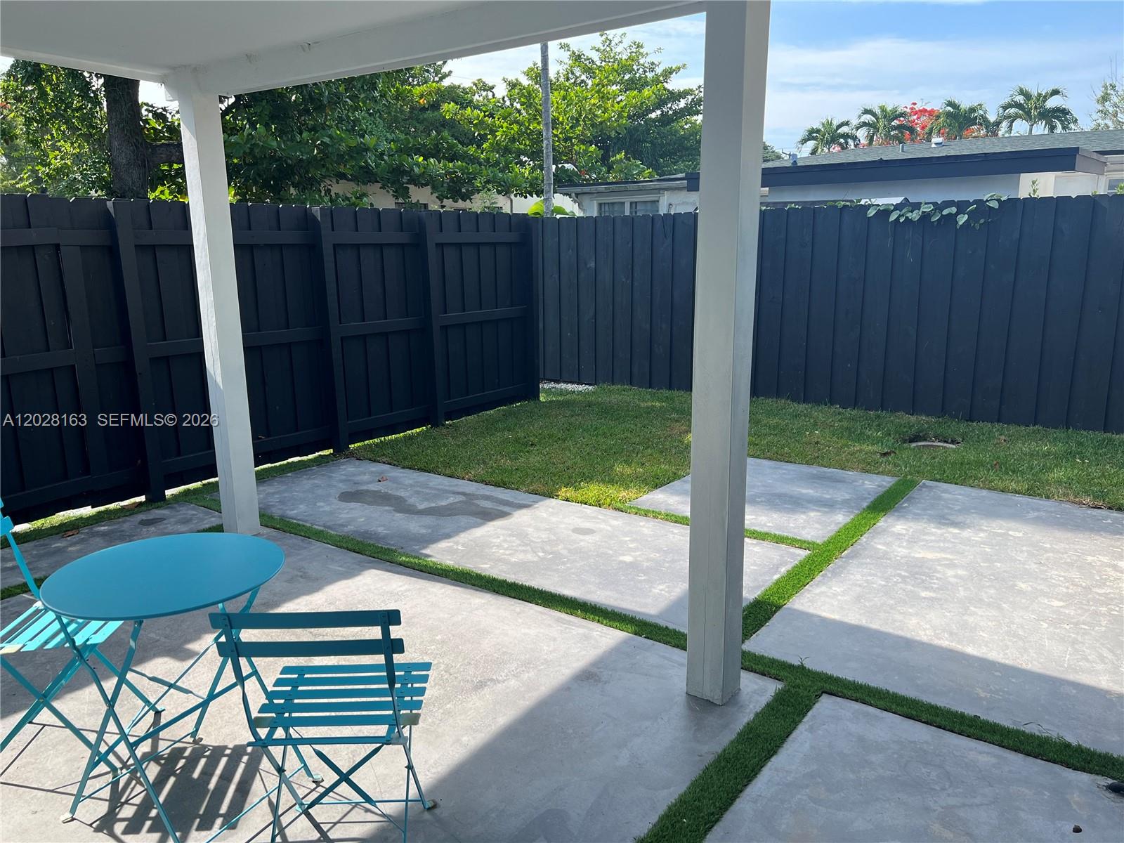 4290 Southwest 9th Street, Unit B Miami, FL 33134 - Photo 5 of 18 a view of a backyard with table and chairs with wooden fence