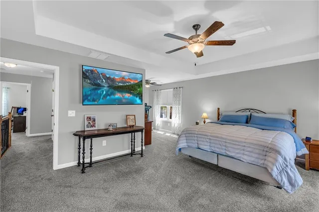 a spacious bedroom with a bed and a chandelier