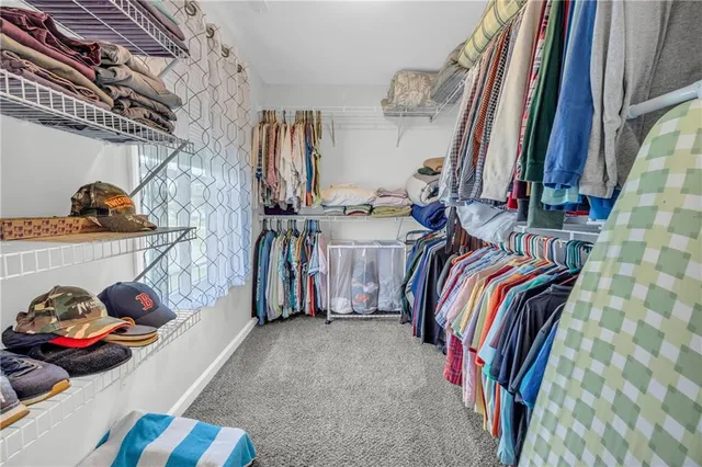 a view of walk in closet with clothes and shoes