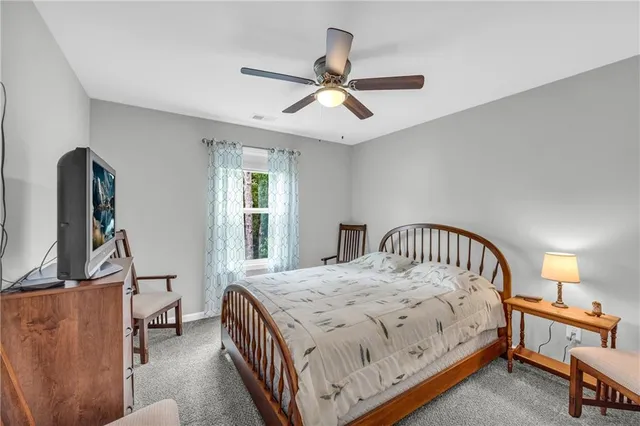 a bedroom with a bed a chandelier and dresser