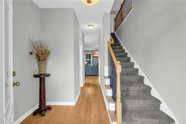 a view of a hallway with wooden floor and staircase
