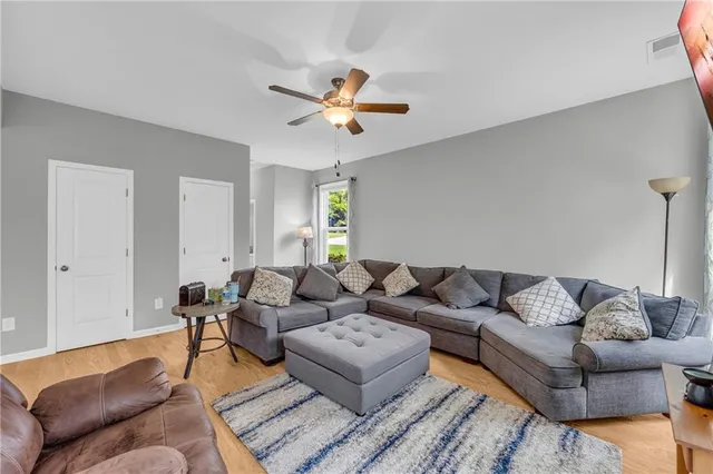 a living room with furniture and a ceiling fan