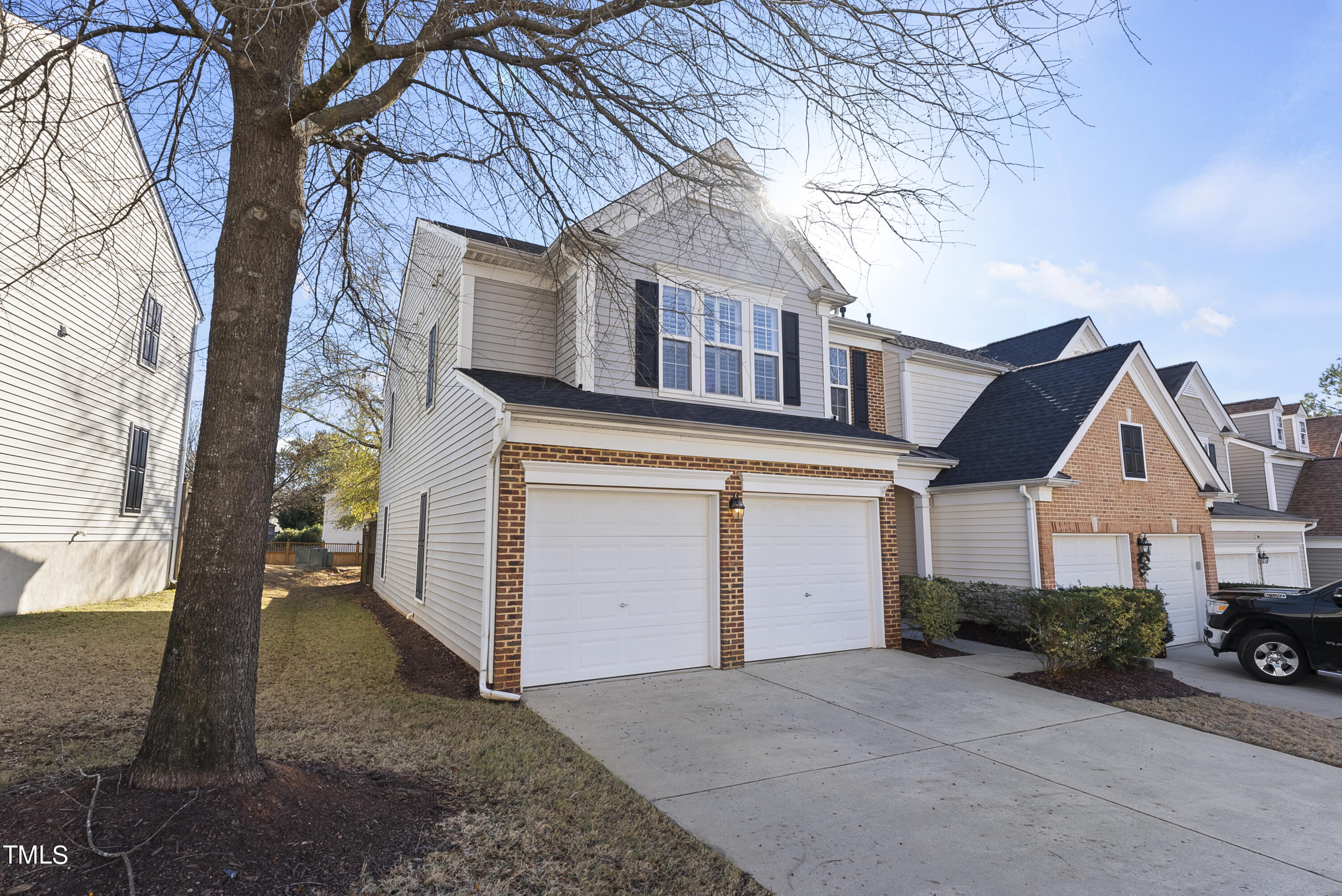 7717 Tanby Court Raleigh, NC 27613 - Photo 2 of 33 a view of a white house with a large tree and a yard