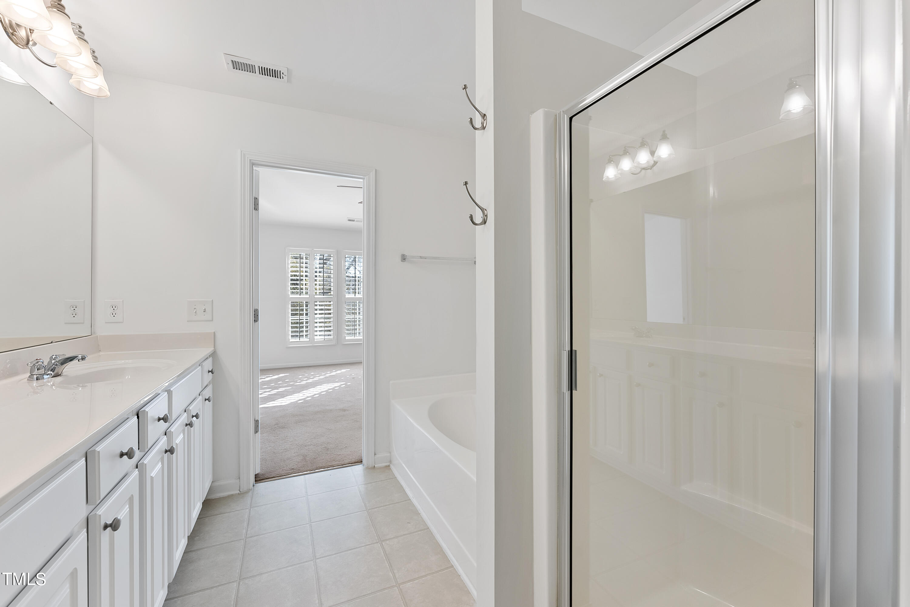 7717 Tanby Court Raleigh, NC 27613 - Photo 28 of 33 a bathroom with a tub sink and mirror