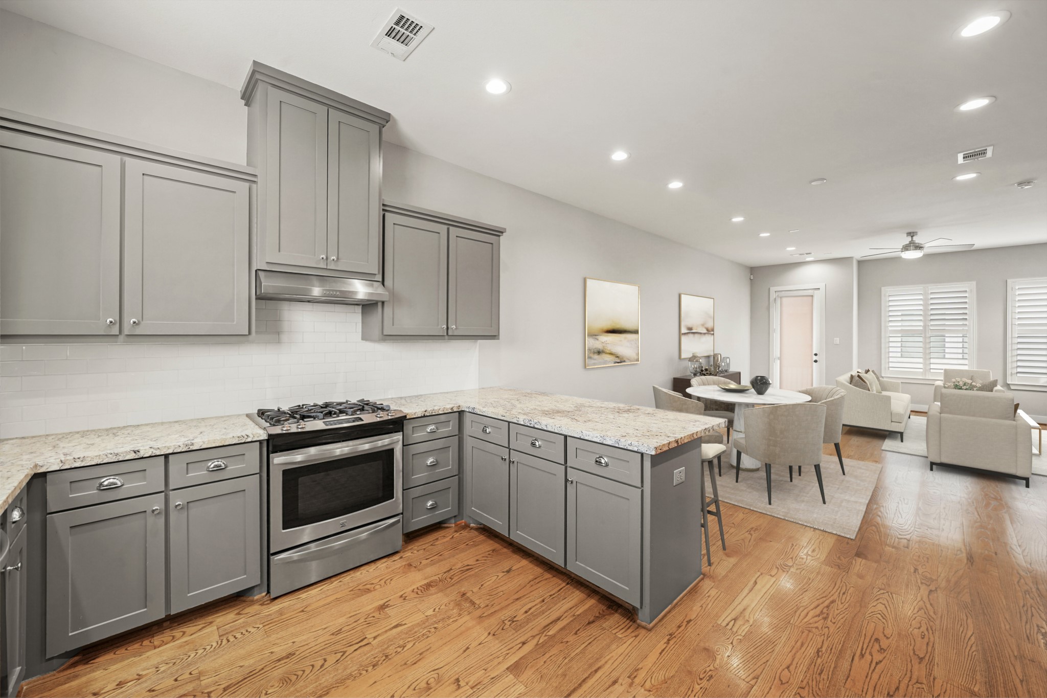 2547 Calumet Street Houston, TX 77004 - Photo 10 of 28 This virtually staged kitchen/dining room exudes modern elegance with its sleek gray cabinetry, polished granite countertop, and contemporary lighting, offering a pristine and inviting space.