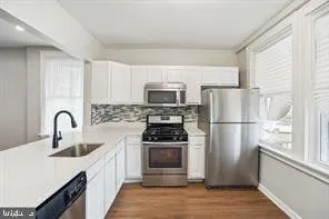 a kitchen with stainless steel appliances a sink stove and cabinets