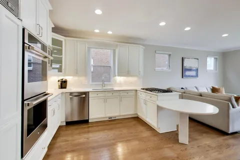 a large kitchen with stainless steel appliances granite countertop a lot of counter space and a sink