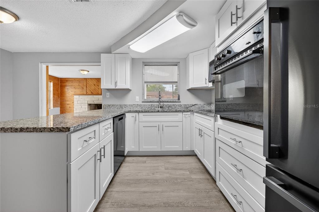 1012 Prescott Lane Holiday, FL 34691 - Photo 16 of 45 a kitchen with granite countertop white cabinets and white appliances