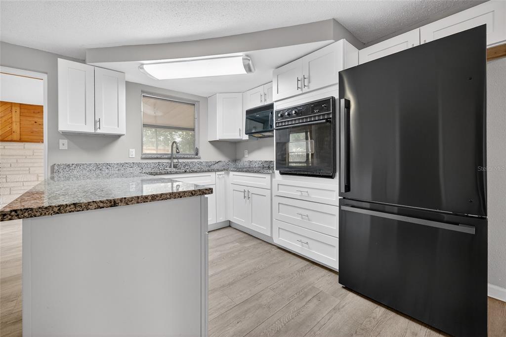 1012 Prescott Lane Holiday, FL 34691 - Photo 18 of 45 a kitchen with granite countertop stainless steel appliances and wooden cabinets