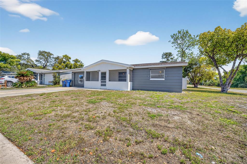 1012 Prescott Lane Holiday, FL 34691 - Photo 2 of 45 a front view of a house with a garden and yard