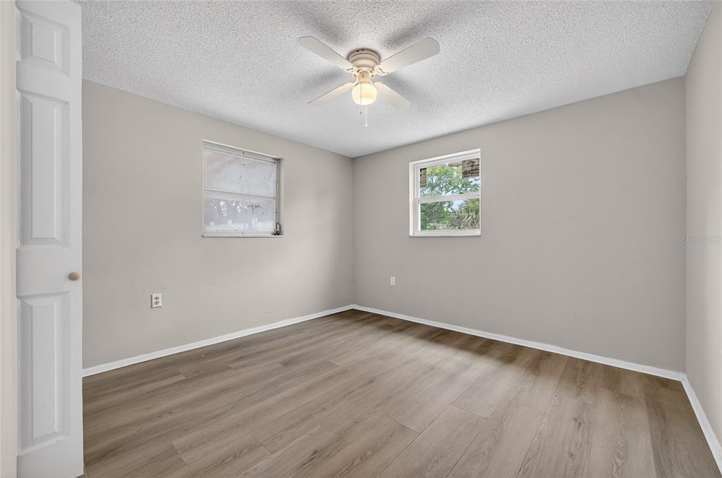 1012 Prescott Lane Holiday, FL 34691 - Photo 23 of 45 an empty room with wooden floor and ceiling fan