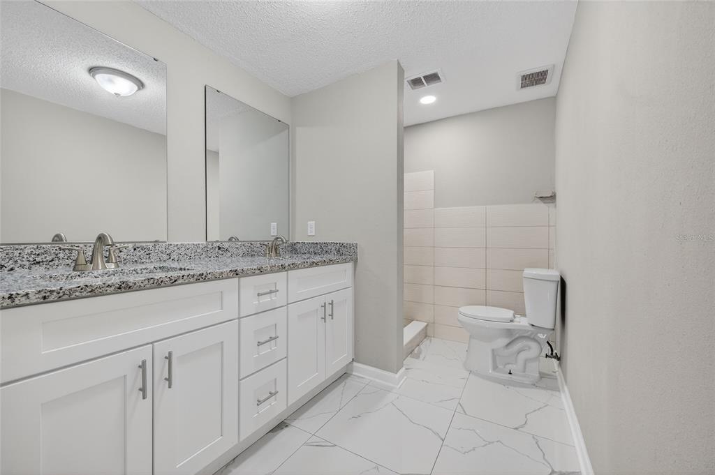 1012 Prescott Lane Holiday, FL 34691 - Photo 28 of 45 a bathroom with a granite countertop sink and a toilet