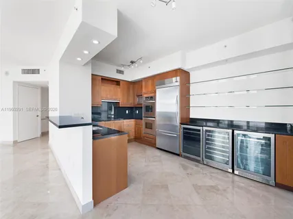 a kitchen with stainless steel appliances kitchen island granite countertop a stove and a refrigerator