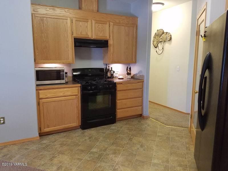 461 Puterbaugh Road Grandview, WA 98930 - Photo 4 of 27 a kitchen with a refrigerator and a stove