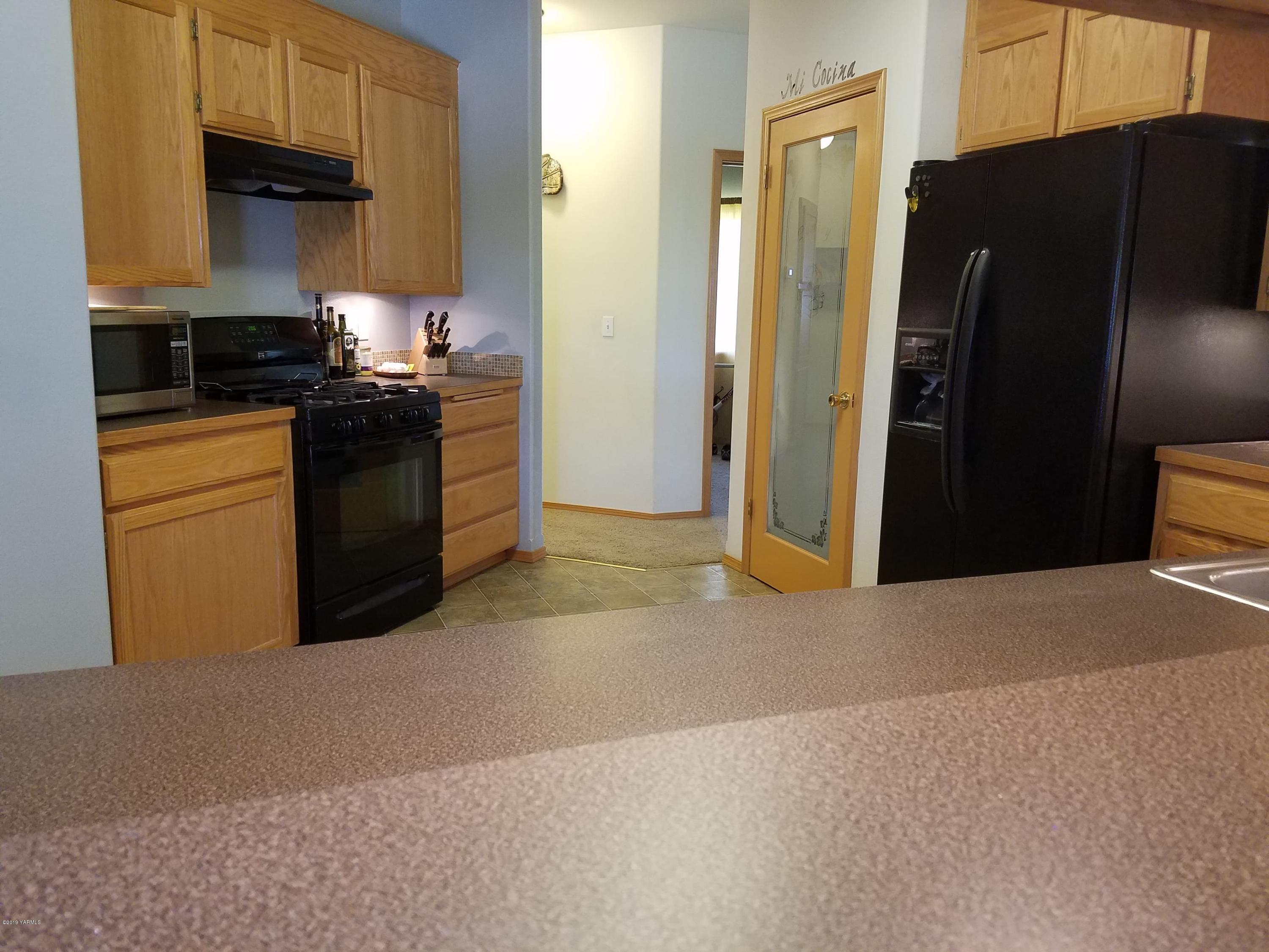 461 Puterbaugh Road Grandview, WA 98930 - Photo 5 of 27 a kitchen with a refrigerator and a stove