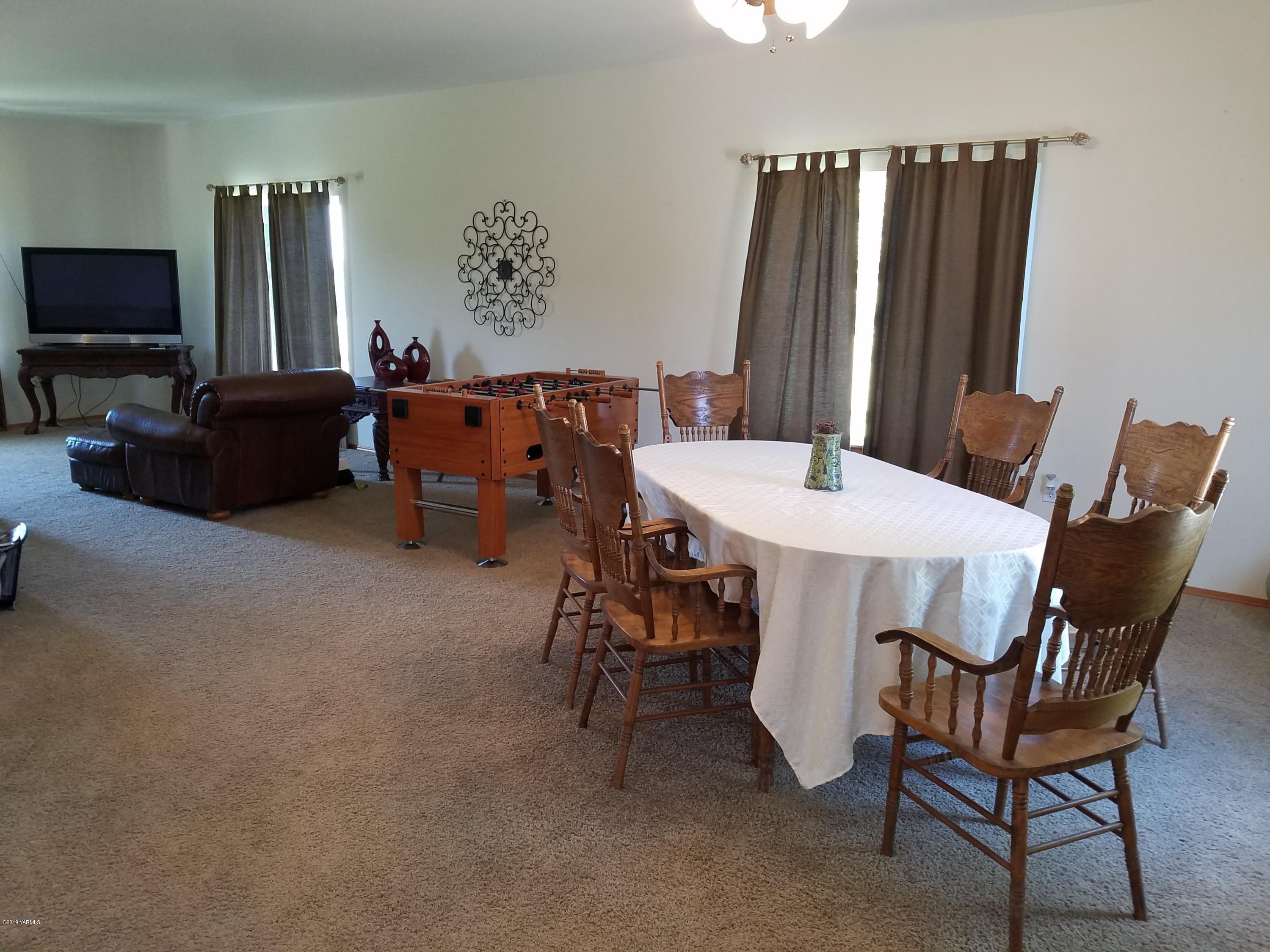 461 Puterbaugh Road Grandview, WA 98930 - Photo 9 of 27 a living room with furniture a flat screen tv and a refrigerator