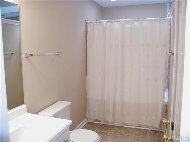 2324 Florida Court Raleigh, NC 27615 - Photo 13 of 17 a bathroom with a shower curtain and a toilet