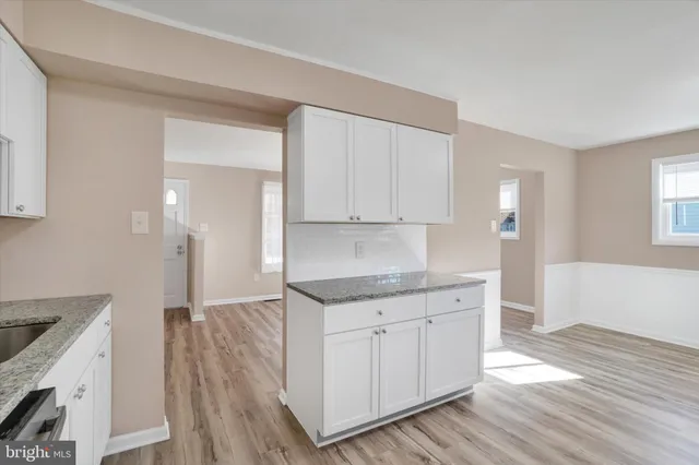 a kitchen with a sink cabinets and wooden floor