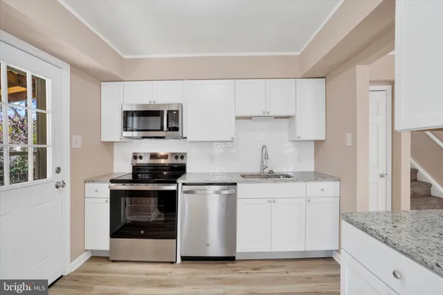a kitchen with stainless steel appliances granite countertop a stove and a sink