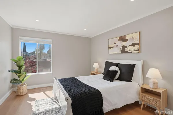 a bedroom with bed and wooden floor