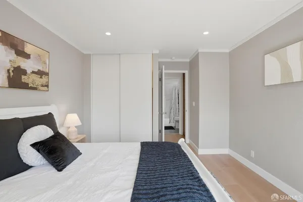 a bedroom with a bed and a painting on the wall