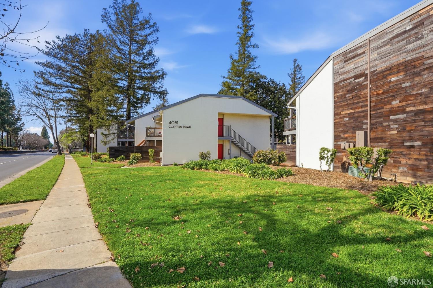 4081 Clayton Road, Unit 235 Concord, CA 94521 - Photo 3 of 27 a view of a white house with a yard and potted plants