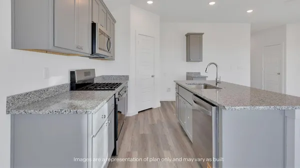 a kitchen that has a sink a stove and cabinets