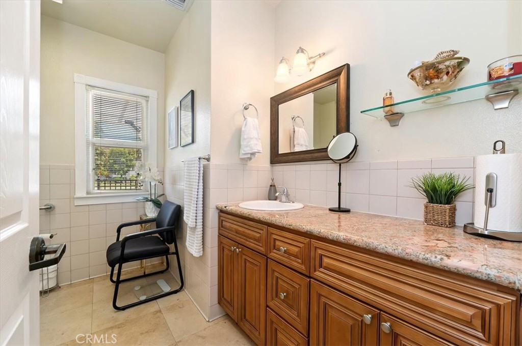 3845 Tenth Street Riverside, CA 92501 - Photo 32 of 45 a spacious bathroom with a granite countertop sink a mirror and a window